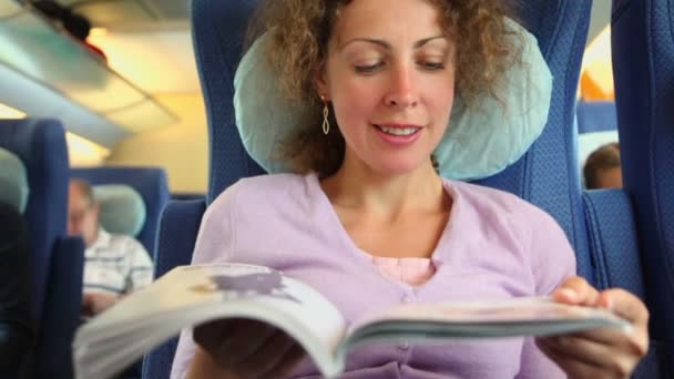 Młoda kobieta czyta książki Kiedy usiąść w fotelu w pociąg trener — Wideo stockowe