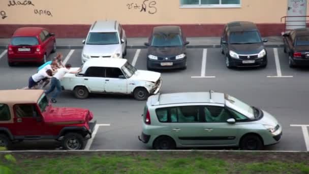 Varios chicos jóvenes empujan coche viejo para ponerlo en marcha — Vídeo de stock