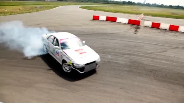 Автомобиль белого цвета въезжает в свою очередь оставляя дымовую петлю — стоковое видео