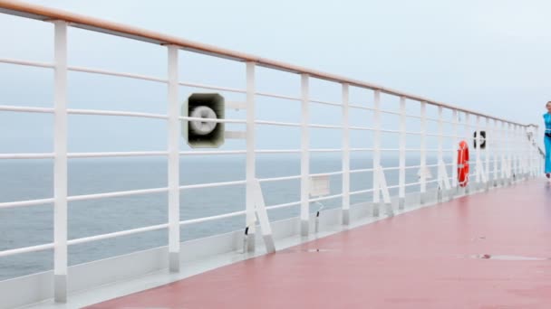 Woman in blue runs on pink deck of floating ship and smile — Stock Video