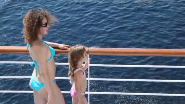 Mother and daughter stand on deck of ship holding to banister — Stock Video