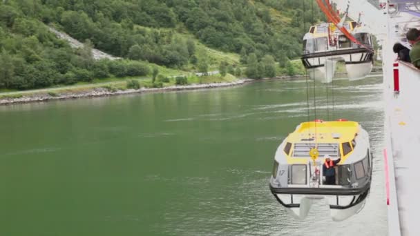 Passengers watch how crane lifts rescue boat with worker on it — Stockvideo
