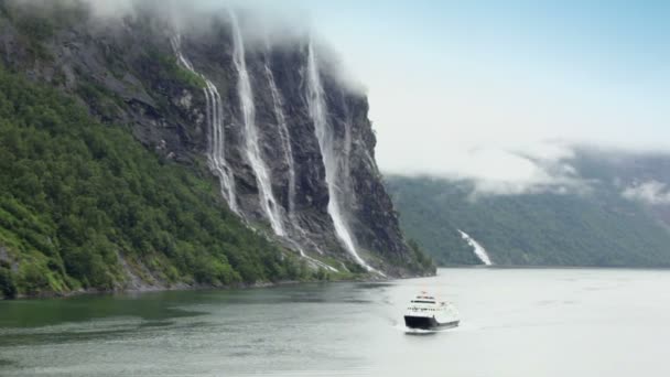 Корабль плавает на фьорде около водопада Семи Сестер на горе — стоковое видео