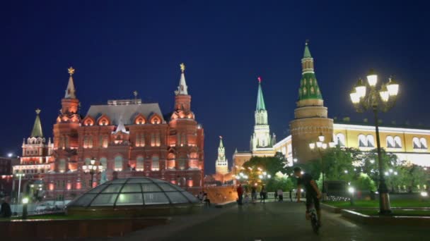 Bicyclist and pedestrians walk by Manezhnaya square near kremlin