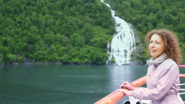 Woman stands on board of ship which float by fjord — Stock Video