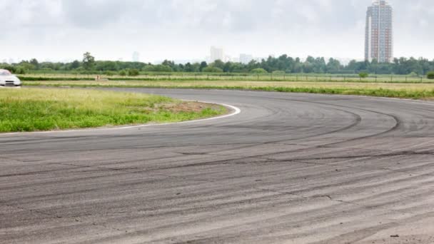 Auto's aangaat draai verlaten rook lus tegen stad landschap — Stockvideo