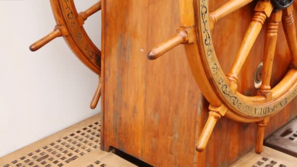 Old steering wheel from wood stands on sailing vessel deck. — Stock Video