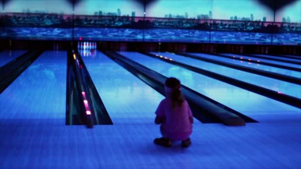Flicka titta på bollen trundles av bowlingbana och slår käglor — Stockvideo