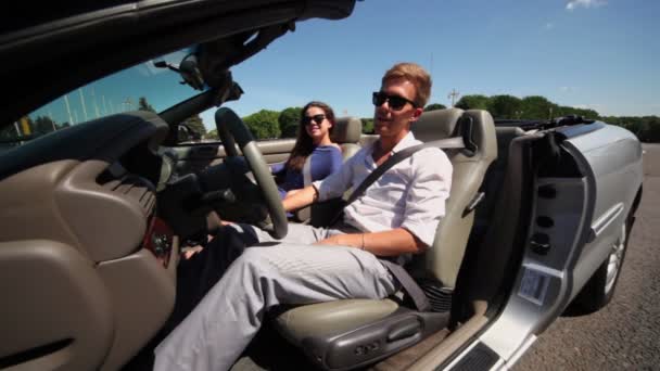 Couple in sunglasses sit in cabriolet with driver door open — Stock Video