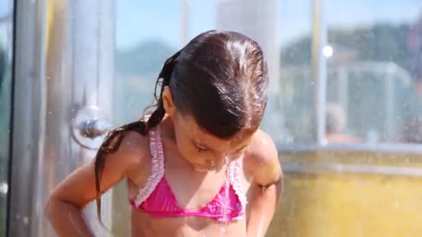 Гарна маленька дівчинка миється під водою в душовій кабіні — стокове відео