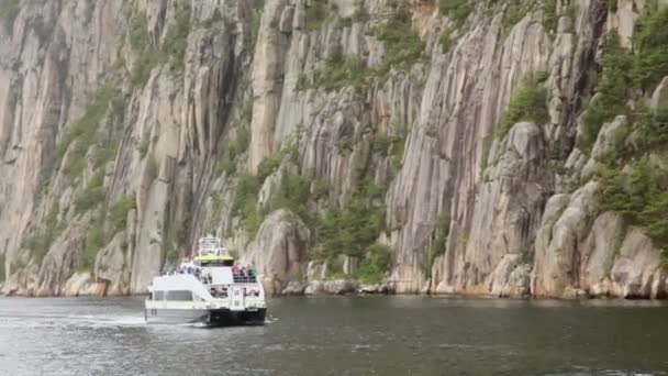 Turisti sul ponte di nave che galleggia da fiordo vicino a scogliera rocciosa — Video Stock