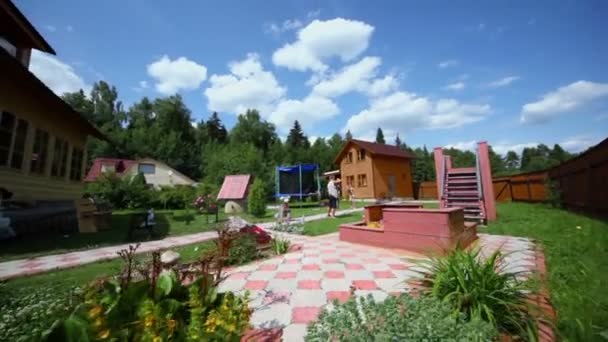 Zwei Jungen spielen auf Hof eines Landhauses unter freiem Himmel — Stockvideo