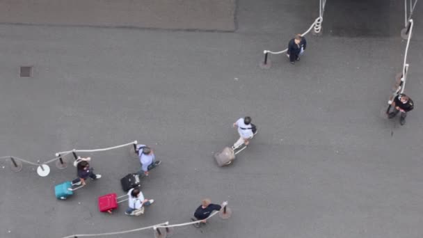 Several passengers walk with their luggage to entrance — Stock Video