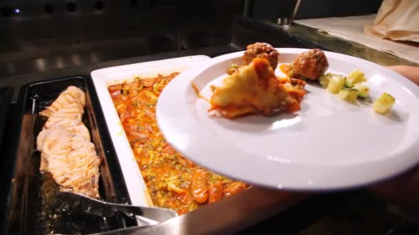 Person puts vegetables and meat to itself in white plate — Stock Video