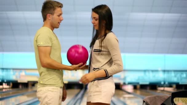 Jong koppel spreken en glimlach in de buurt van bowling lane in club — Stockvideo
