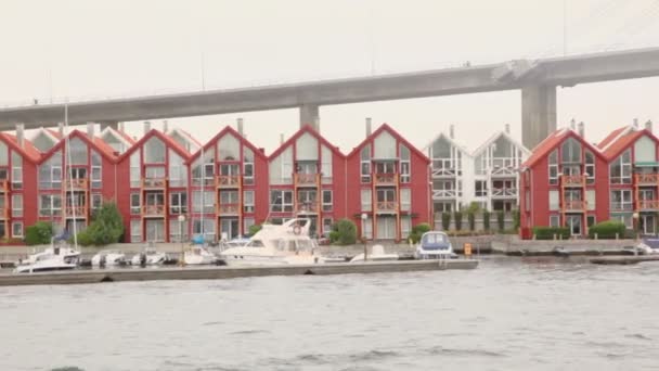 Bateaux sur amarrage au village près d'un énorme pont suspendu — Video