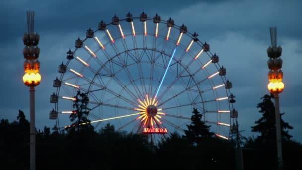 Roda gigante e Moscou 850 inscrição à noite no parque VDNH — Vídeo de Stock