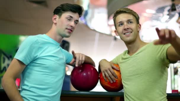 Friends stand in bowling club and show on somebody — Stock Video