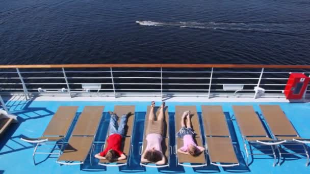 Mother, son with daughter lie in chaise lounge on liner deck — Stock Video