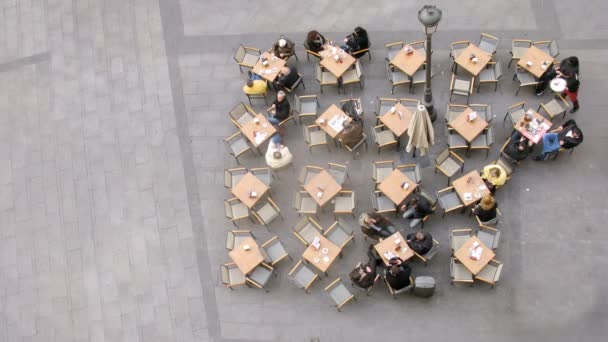 La gente se sienta en la cafetería pequeñas mesas en la calle, lapso de tiempo — Vídeo de stock