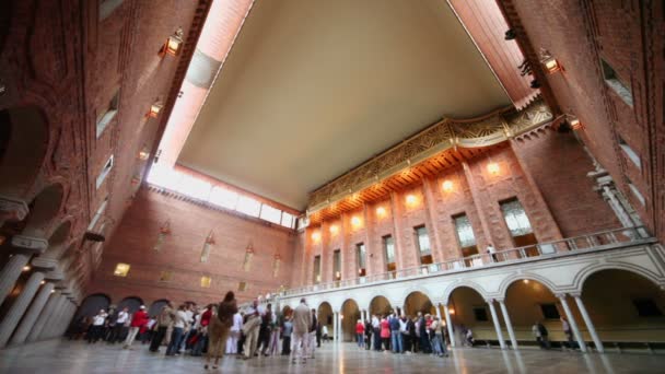 Veel toeristen lopen en kijk rond blauwe kamer in stadhuis — Stockvideo