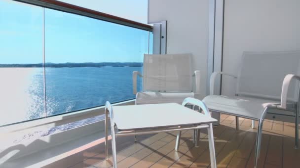 Twee stoelen en tafel op balkon op schip dat in zee drijft — Stockvideo