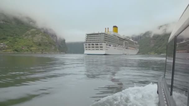 Face arrière du bateau de sauvetage qui flotte vers un énorme croiseur sur le fjord — Video