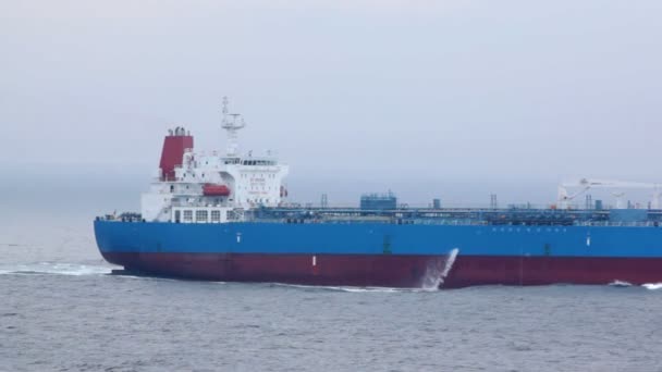 Back part of tanker floating on waves in cloudy weather — Stock Video