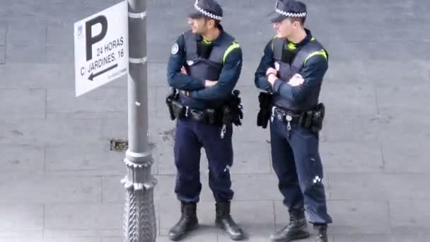 Zwei Polizisten stehen auf Straße in der Nähe gehen Menschen — Stockvideo
