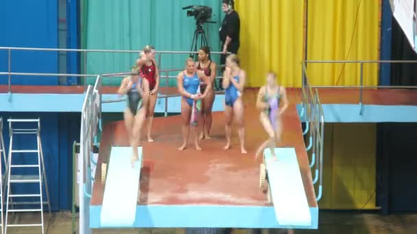 Sportswomen entrenar saltos síncronos desde trampolín en parejas — Vídeos de Stock