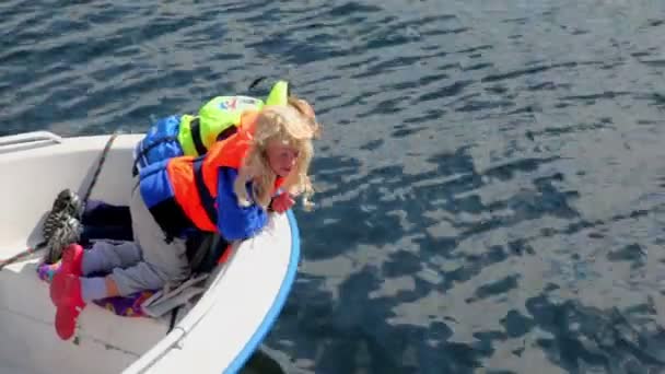 Los padres con niños flotan en barco con motor, mujer muestran peces — Vídeo de stock