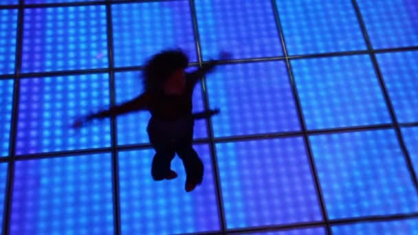 Donna gira in danza al buio discoteca con pavimento illuminato — Video Stock