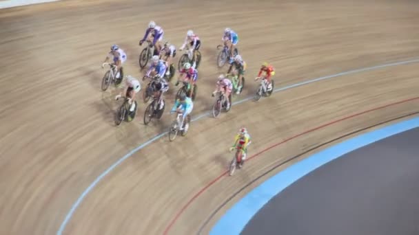 Group of bicyclists ride by track, shown in motion — Stock Video