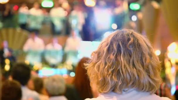 Vrouw klapt handen in hal met groep van obers die dansen — Stockvideo