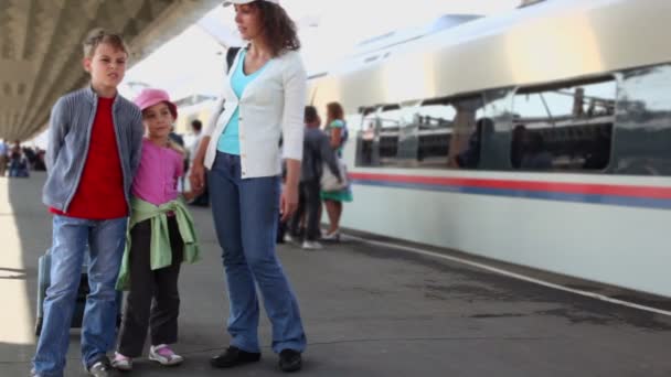 Mother speaks with kids when they stand together at station — Stock Video
