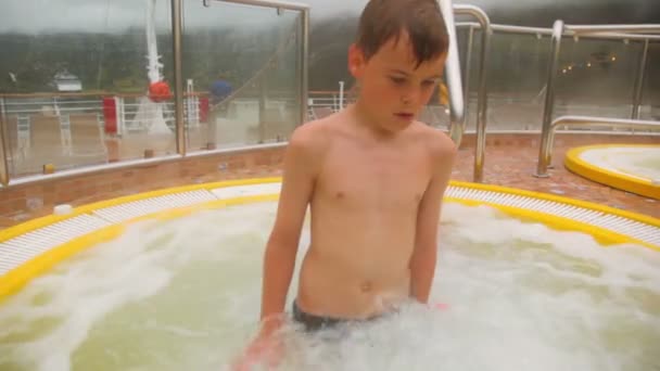 Two kids sit in pool with hot water, steam cover all around — Stock Video