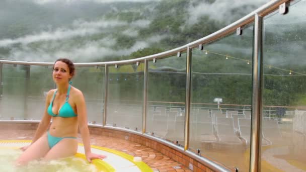 Giovane donna si siede al bordo della piscina con acqua calda — Video Stock