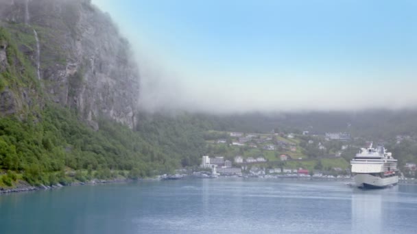 Fiord con grande liner vicino al villaggio costiero sotto la montagna — Video Stock