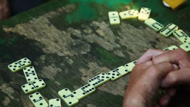 People play dominoes on table, only hands are visible — Stock Video