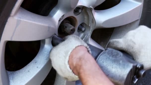 Homem desparafusar porcas da roda por chave de fenda automática, vista close-up — Vídeo de Stock