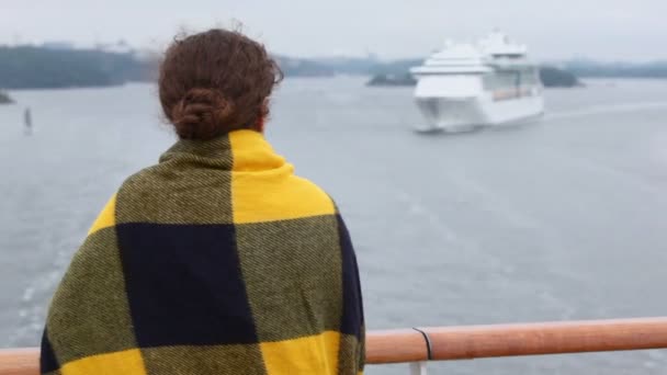 Woman wrapped in plaid stand at deck and watches on cruiser — Stock Video