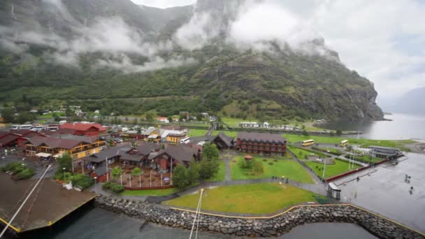 Pequeño puerto con casas al final del valle del fiordo entre montañas — Vídeos de Stock