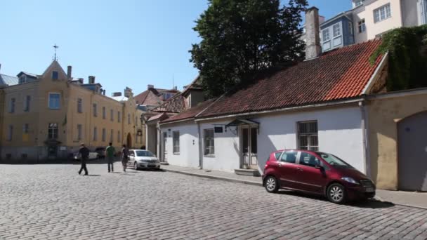 Тротуарная плитка улицы старого города с машинами и людьми — стоковое видео