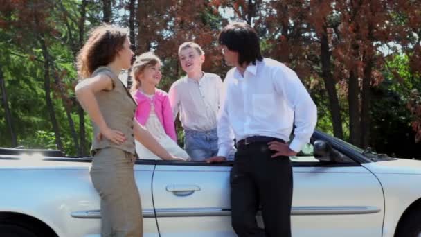 Eltern lehnen Cabrio ab und ihre Kinder stehen im Cabrio — Stockvideo