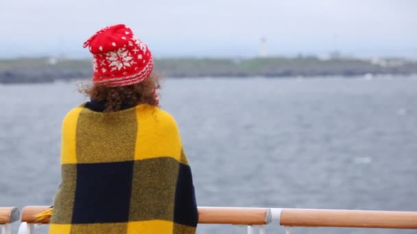 Жінка стоїть на палубі судна, повернувшись — стокове відео