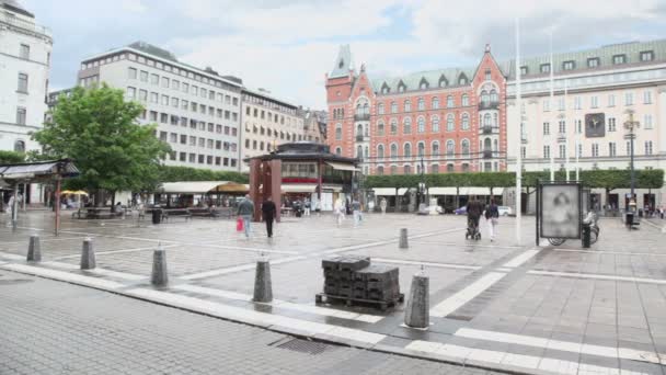 Obywatele chodzić przy placu norrmalmstorg w Sztokholmie w deszczowy dzień — Wideo stockowe