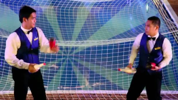 Twee barmannen jongleert door flessen in de buurt van zwembad met net — Stockvideo