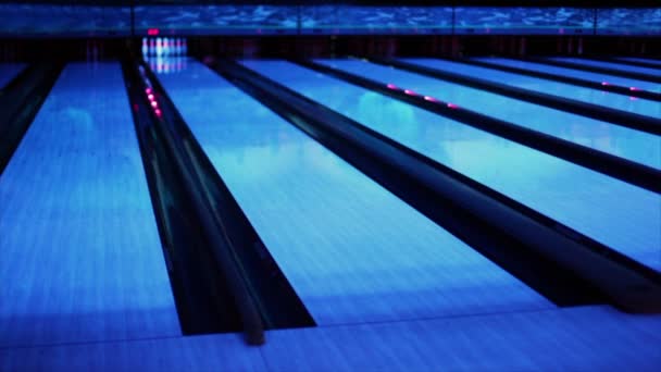 Ball thrundles in flume near bowling lane at dark club — Stock Video