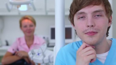 Hemşire çocuk gülümsüyor closeup ve doktor odaklanmamış arkasında oturuyor