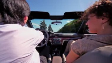 Çift cabriolet oturmak ve yoldan güneşli bir yaz günü binmek